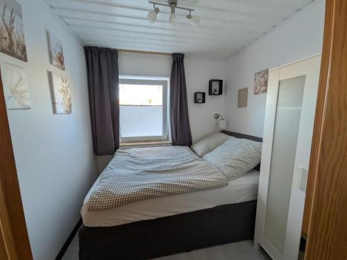 a bed in a small room with a window at Ferienwohnung Tanja in Winterberg