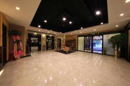 a lobby with a waiting area with a couch and a table at Kobos Hotel in Seoul