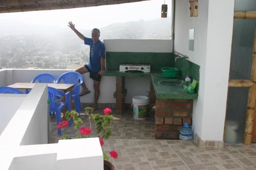 a man sitting at a table in a balcony with a view at Cruz del Sur in Pucusana