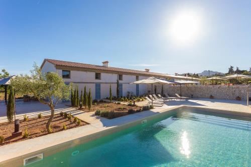 a swimming pool in front of a house at Sa Nau Agroturismo - Adults Only over 16 in Portocolom