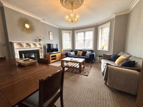 a living room with a table and a couch and a fireplace at Silverdale Holiday Apartments in Eastbourne