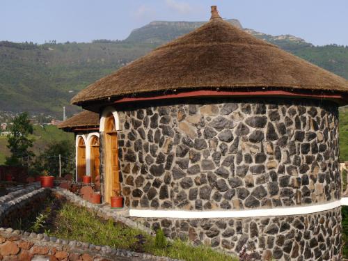 a large stone building with a thatch roof at Sora Lodge Lalibela in Lalībela
