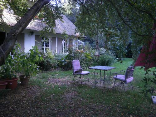 two chairs and a table in front of a house at Le clos des mûriers in Hautot-sur-Mer