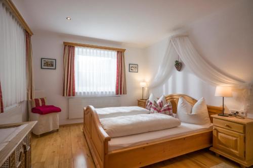 Schlafzimmer mit einem Bett und einem Fenster in der Unterkunft Haus Mader in Hippach