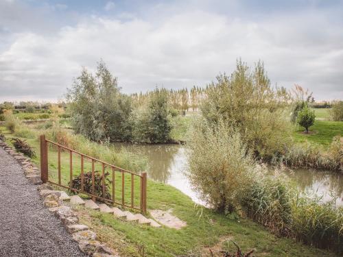 a fence on the side of a river at Lake View Lodges - 25076 in Old Leake