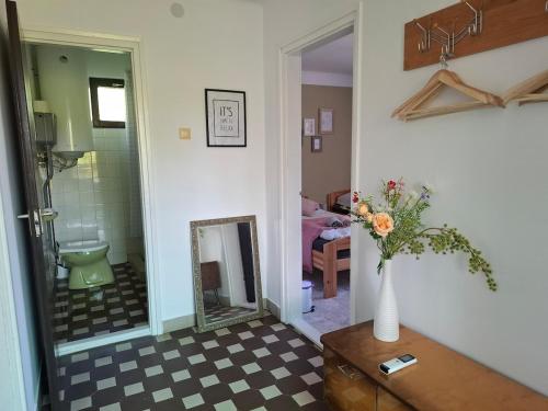 a hallway with a mirror and a vase with flowers on a table at Szemben apartment in Csengőd