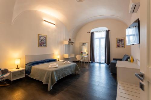 a bedroom with a bed and a living room at La Dama del Castello in Bosa