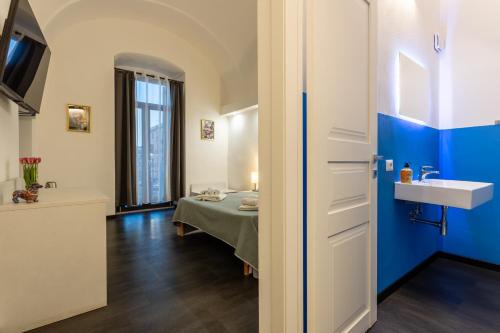 a room with a bed and a sink at La Dama del Castello in Bosa