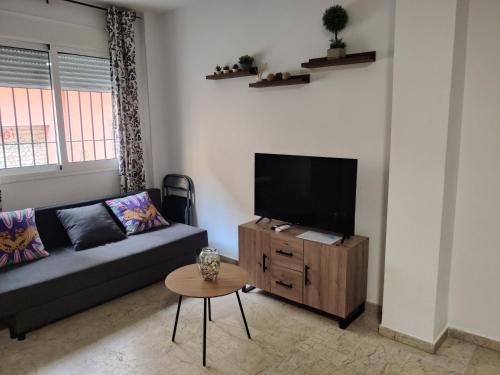 a living room with a couch and a flat screen tv at playa Almería zapillo loft in Almería
