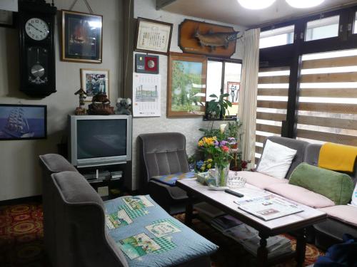a living room with a table and a tv at Seisenso in Nozawa Onsen