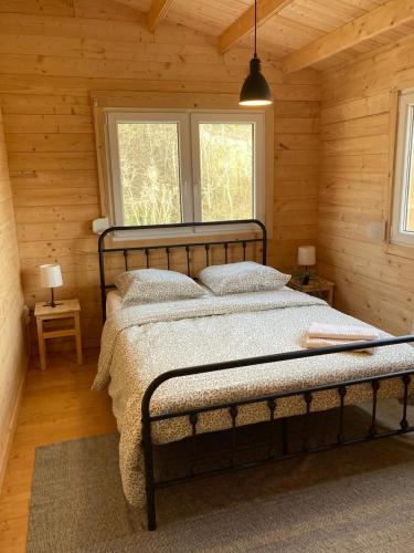 a bedroom with a bed in a log cabin at Au pied du plateau in Campagne-sur-Aude