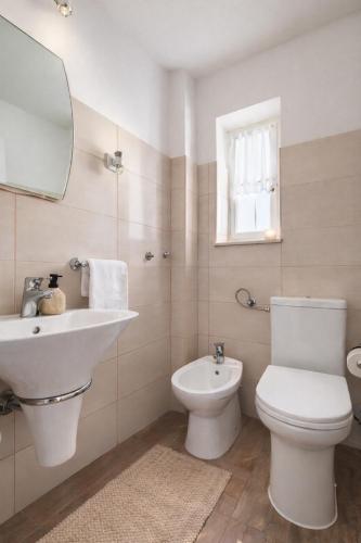 łazienka z umywalką, toaletą i lustrem w obiekcie Penthouse Matkovic w Splicie