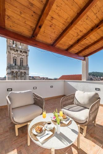 un patio con due sedie e un tavolo sul tetto di Penthouse Matkovic a Spalato (Split)