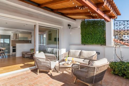 Un patio con sillas, un sofá y una mesa. en Penthouse Matkovic, en Split