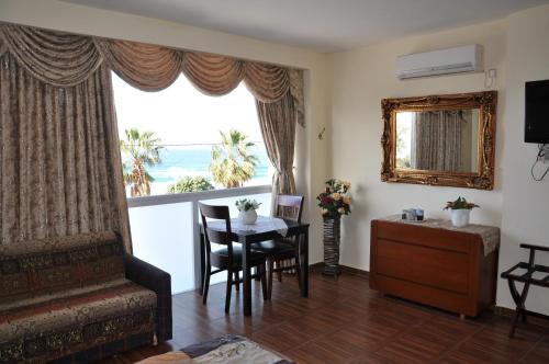 Hotel Suites Bat Yam في بات يام: غرفة معيشة مع طاولة ونافذة كبيرة