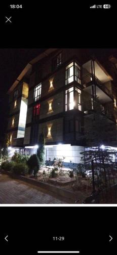 a large building with lights in front of it at Likefront Apartment Issyk-Kul in Bosteri