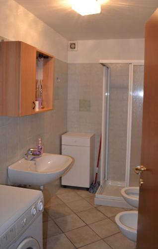 a bathroom with two toilets and a sink and a shower at Pinzolocasa in Pinzolo