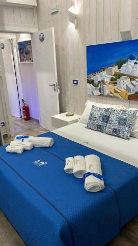 a large bed with blue sheets and towels on it at B&B Santorini in Scalea