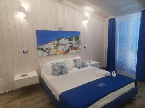 a bedroom with a large bed with blue sheets and pillows at B&B Santorini in Scalea