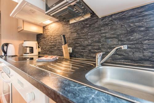 a kitchen with a sink and a counter top at Apartpension Oberhauser in Kaprun