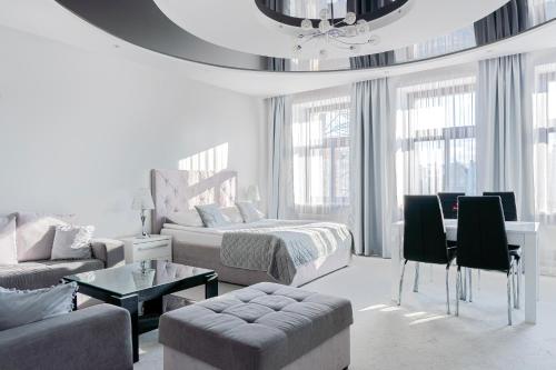 a white living room with a bed and a couch at Kamienica Pod Neptunem - Rynek Puck - Śniadanie w cenie - 200m do Molo in Puck
