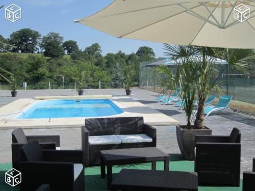 a swimming pool with chairs and an umbrella next to a table and sidx sidx sidx at Chalets de la Plaine in Villebret