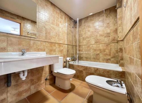 a bathroom with a toilet and a sink and a tub at Spa Valley II experiences Penthouse con Piscina climatizada y Yacuzzi in Villanueva de Río Segura