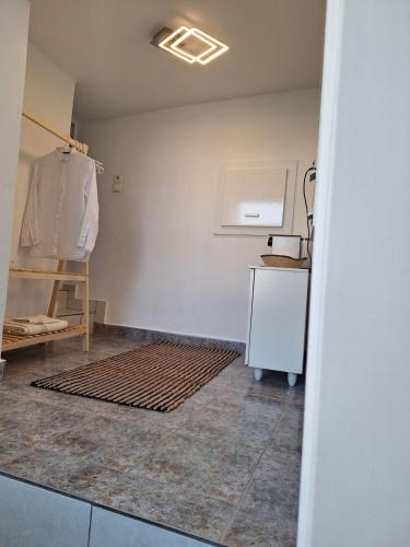 a room with a white wall and a rug at Perla in Pythagoreio
