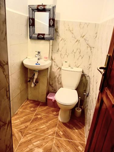 a bathroom with a toilet and a sink at Dar INNÂ in Aït Benhaddou