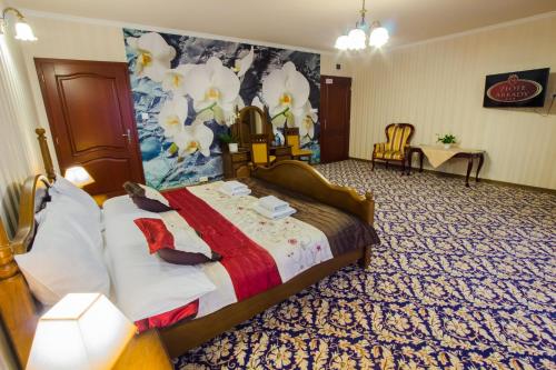 a hotel room with a bed and a painting on the wall at Złote Arkady in Częstochowa