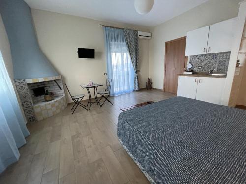 a bedroom with a bed and a table and a fireplace at Namastè Apartments Agrigento in Agrigento