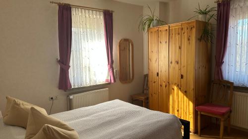 a bedroom with a bed and a wooden cabinet at Ferienwohnung Juttchen in Roßleben