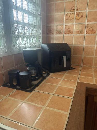 a kitchen with a toaster sitting on a tiled floor at Kaz Toutoune in Saint-Leu