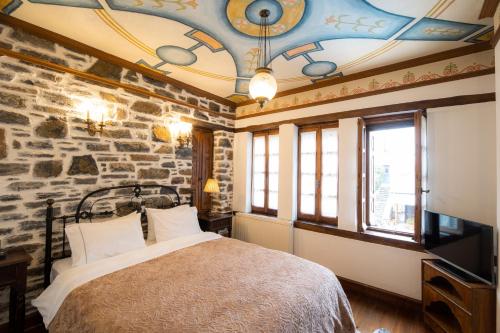 a bedroom with a bed and a stone wall at Archontiko Naoumidi in Portaria