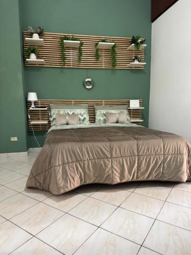 a bedroom with a large bed and green walls at IL COVO DEL PESCATORE in Pozzuoli