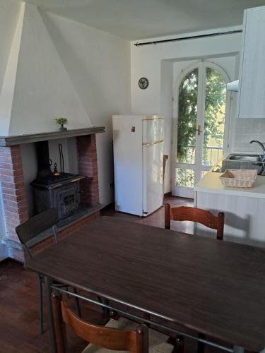 a kitchen with a wooden table and a refrigerator at L'edera in Tuscania