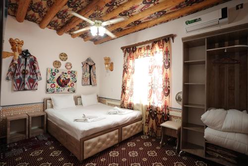a bedroom with a bed and a window in a room at Rasulboy Guest House in Khiva