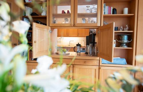 a kitchen with wooden cabinets and a coffee maker at Heideidyll - Wohnung mit WLAN, Balkon, Grill & Garage in Schneverdingen