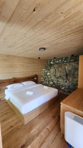 a bedroom with a bed in a wooden room at Chalet Jezerca in Valbonë