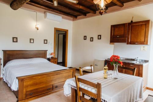 a bedroom with a bed and a table with two chairs at Agriturismo Le Caldane in Colà di Lazise