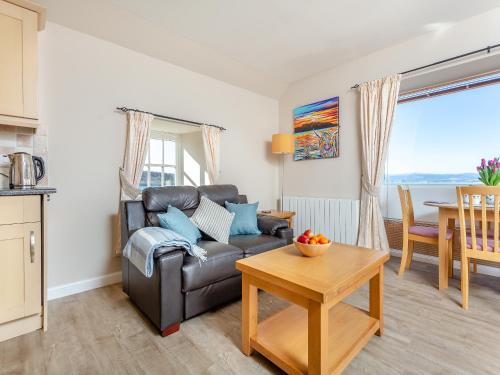 a living room with a couch and a table at Harbour View in Cromarty