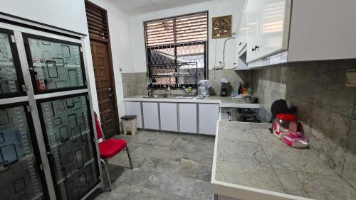 a kitchen with a sink and a red chair at Rumah Mewah Johar in Pontianak