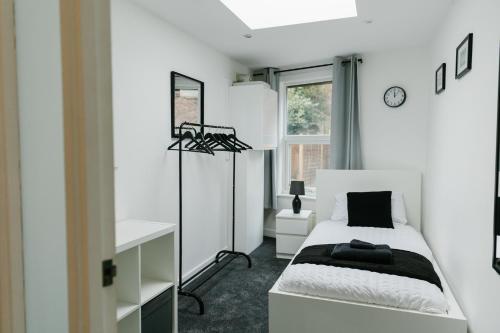 a white bedroom with a bed and a window at Charming Coastal Retreat in BN2 in Brighton & Hove