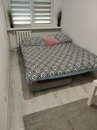 a bedroom with a bed with a comforter and a window at Zakole Street in Konin