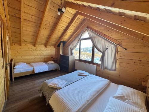 a bedroom with two beds in a log cabin at magiy cotteg in Rozhanka Nizhnyaya