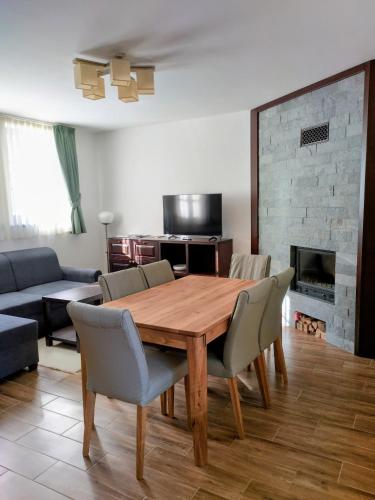 a living room with a wooden table and chairs at City-Top Panorama House & Apartments in Esztergom