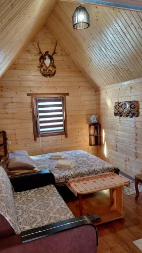 a room with two beds and a table in a attic at Садиба під Чертежиком 2 in Kolochava