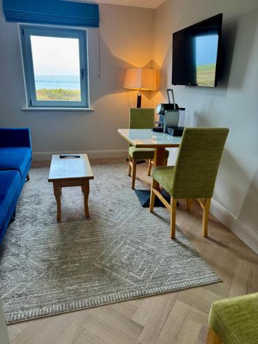 a living room with a table and a couch at Connemara Sands Hotel & Spa in Clifden