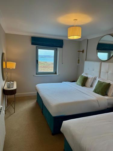 a bedroom with two beds and a window at Connemara Sands Hotel & Spa in Clifden