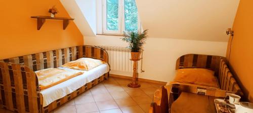 a small bedroom with a bed and a window at Dworek Myśliwski in Łaziska